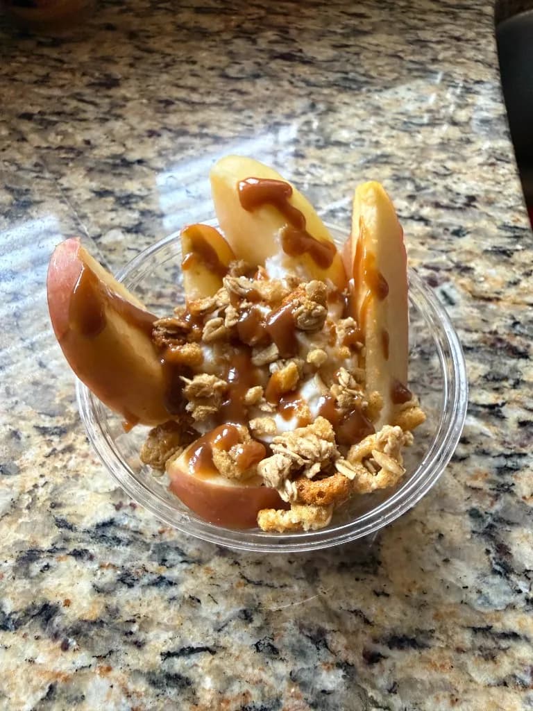 Apple slices with caramel drizzle over a crunchy granola topping